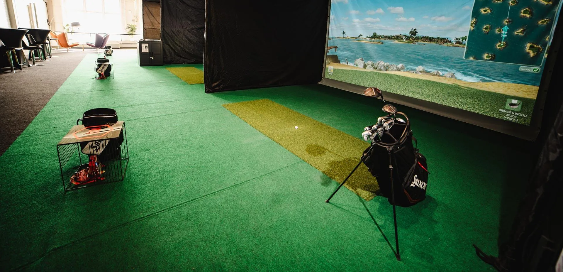 Pelaaja lyö palloa FlightScope Mevo+ -golfsimulaattorissa