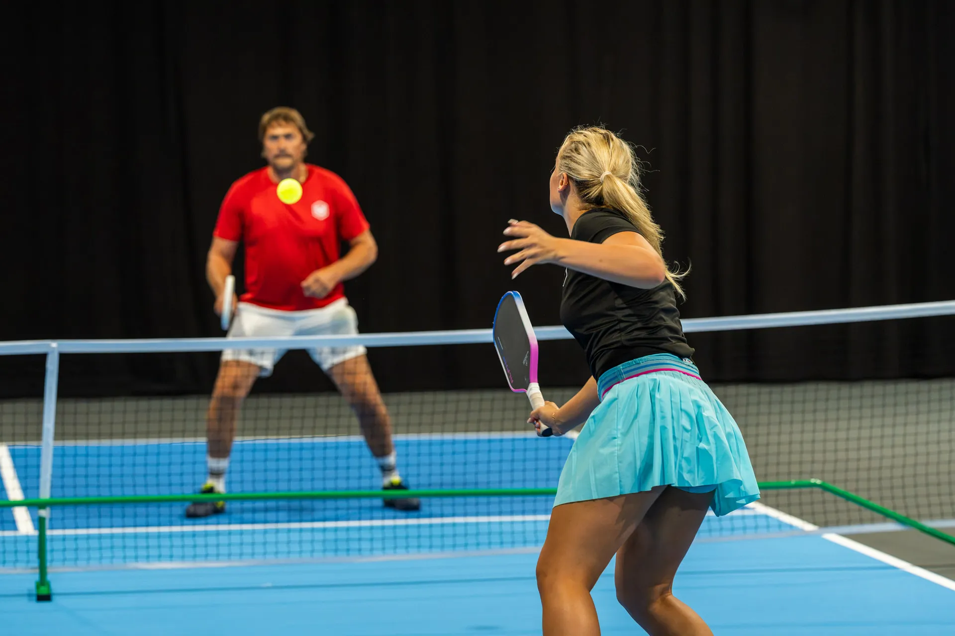 Pelaajat verkon molemmin puolin Social Sports Clubin pickleball-kentällä